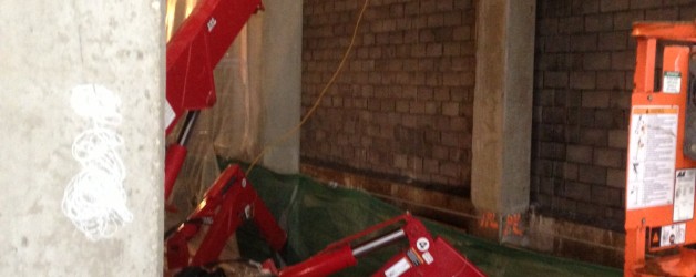 Spydercrane with manbasket next to brick wall of Chicago building